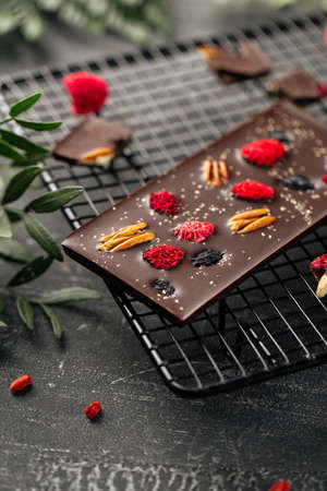 Closeup on handmade chocolate bar with pecan nuts and dried berriesの写真素材