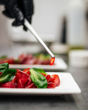 Placing pepper on the sliced prosciutto plateの写真素材