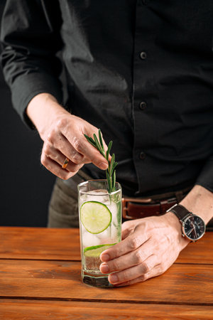 Man making fresh gin tonic cocktail with limeの写真素材