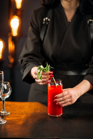 Woman making bloody mary cocktail with celeryの写真素材
