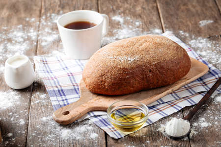 Side view on gray loaf of bread with olive oil