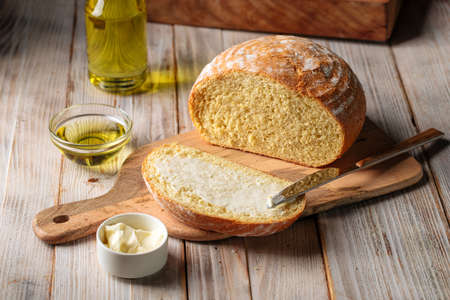 Cut loaf of olive oil bread spread with butter