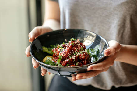 Holding bowl of chicken in spicy sauce with daikonの写真素材