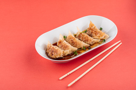 Japanese gedza dumplings with soy sauce on pinkの写真素材