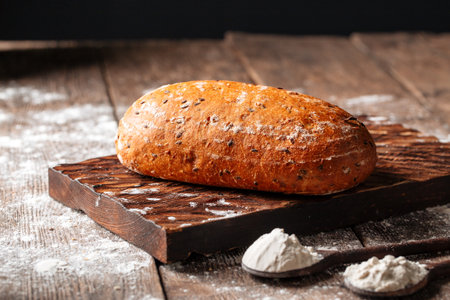 Loaf of white wheat bread on a wooden boardの写真素材
