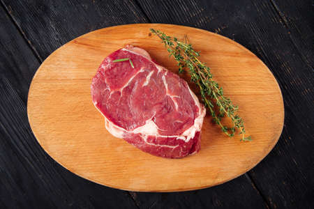 Top view on raw piece of meat with rosemary