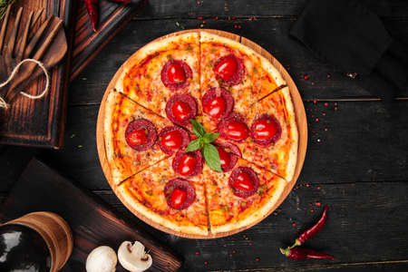 Pepperoni tomato pizza on the wooden backgroundの写真素材