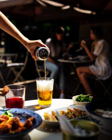 Dining in cafe terrace with beer and japanese foodの写真素材