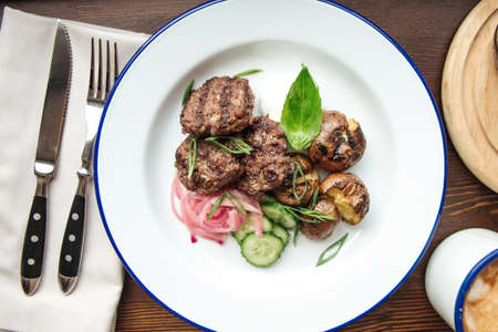 Mini beef cutlets and a mug of coffeeの写真素材