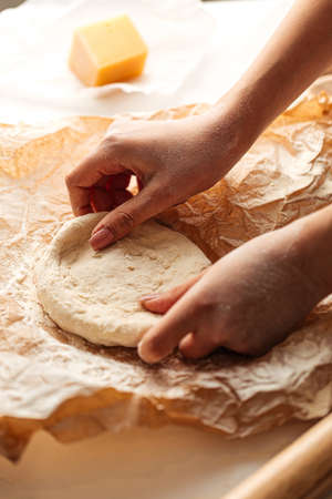 Kneading dough for pizza cooking on the paper