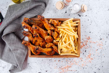 Fried and glazed chicken legs with friesの写真素材