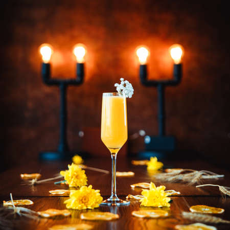 Glass of bellini cocktail on decorated tableの写真素材