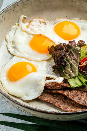 Gourmet fried eggs with roast beef and saladの写真素材