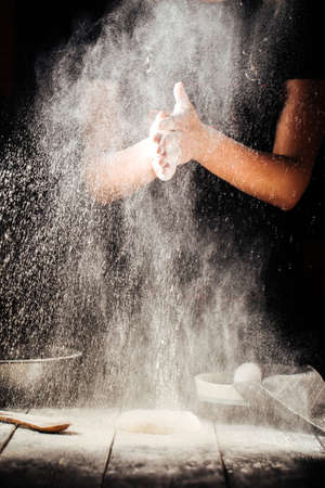 Baker hand with flour pizza preparation