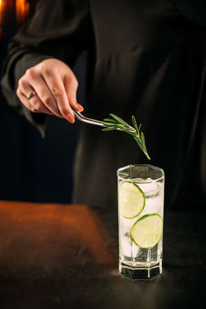 Making fresh gin tonic cocktail with lime slices