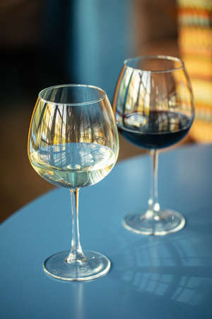 Two glasses of red and white wine in the restaurantの写真素材