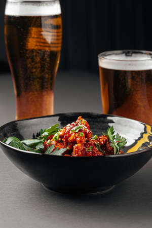 Japanese karaage chicken with beer on a gray