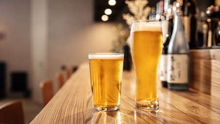 Two glasses of japanese light beer on a bar deskの写真素材