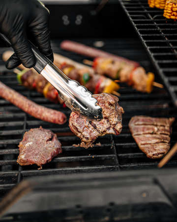 Grilling sausages and skewers on a barbecue