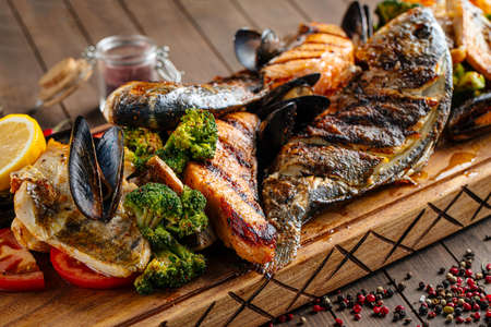 Assorted grilled fish set on wooden serving boardの写真素材