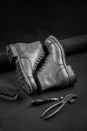 Handcrafted brown leather shoes with cobbler tools