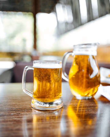 Glass mug and jug of beer on the tableの写真素材