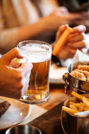Holding glass mug of fresh cool beer