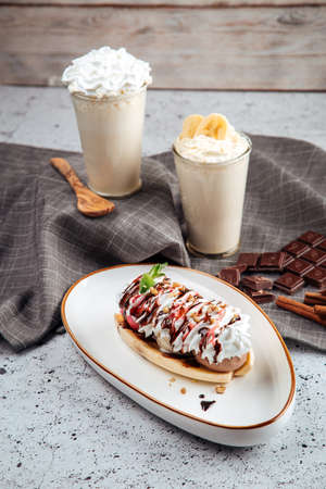 Banana split dessert with nuts with milkshakes