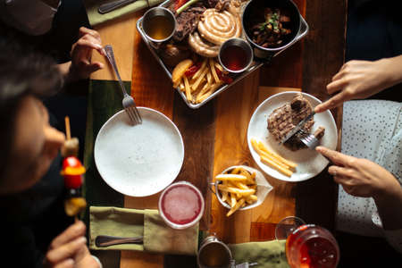 Dining table eating steak and appetizerの写真素材