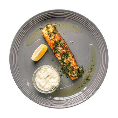 Isolated plate of grilled salmon steak with sauceの写真素材