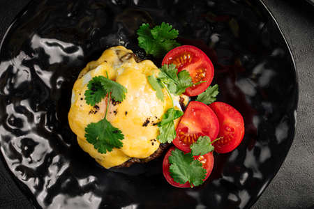 Baked cutlet with melted cheese and tomatoesの写真素材