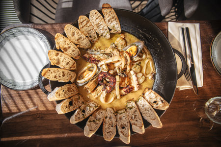 Pan of seafood stew with toasted bread