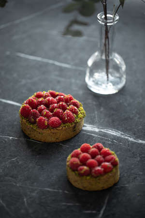 Two delicious raspberry tartlets with pistachiosの写真素材