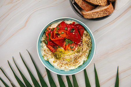 Portion of hummus bowl with baked pepperの写真素材