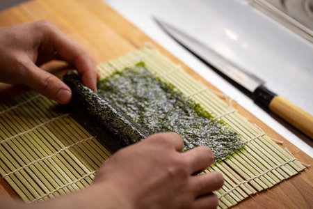 Chef cooking sushi rolls with rice and noriの写真素材