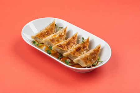 Portion of japanese gyoza dumplings on pink