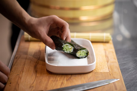 Chef making sushi roll with cucumberの写真素材