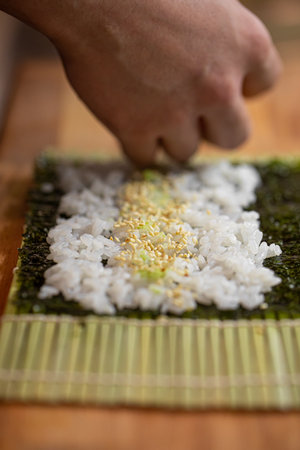 Chef making sushi roll with cucumberの写真素材