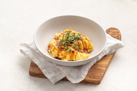 Portion of asian style scrambeled eggs with herbs