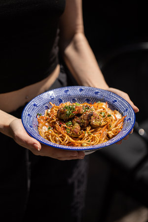Holding bowl of asian udon wok noodlesの写真素材