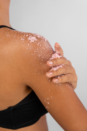 Woman applying scrub cosmetics on her skinの写真素材