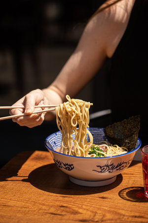 Woman eating japanese ramen noodle soup