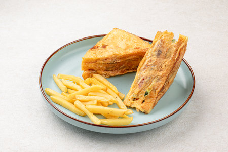 Portion of sandwich fried in egg with french friesの写真素材