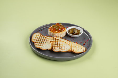 Portion of baked brie with jalapeno and toastの写真素材