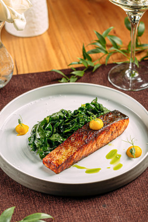 Salmon steak with spinach on served tableの写真素材