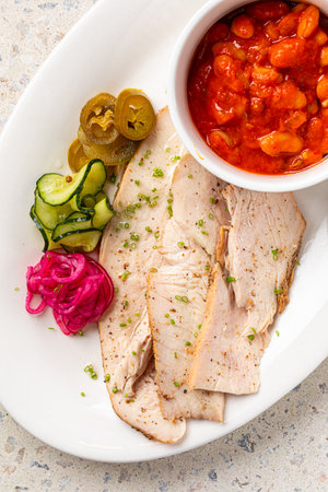Portion of chicken with beans and picklesの写真素材