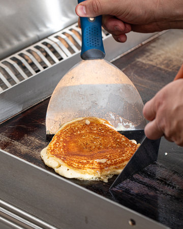 Cooking fresh pancake on black panの写真素材