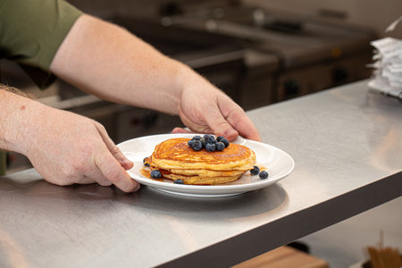Chef serving sweet blueberry pancakesの写真素材
