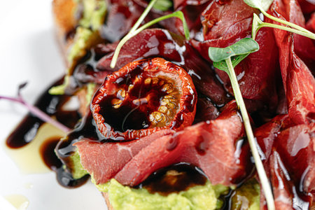 Gourmet prosciutto toast with avocado and balsamicの写真素材