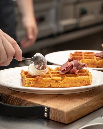 Chef puts cottage cheese on waffle with brisketの写真素材